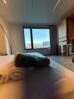 a bedroom with a large bed with a large window at Apartaestudio in Medellín