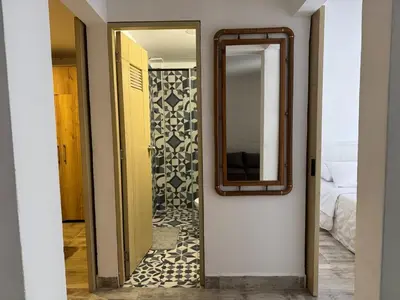 a hallway with a mirror and a room with a bed at Casa Alba, El Poblado in Medellín