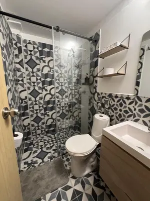 a bathroom with a shower and a toilet and a sink at Casa Alba, El Poblado in Medellín