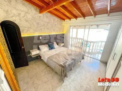 a bedroom with a bed and a large window at Private pool and Jacuzzi rentals in Medellin - VIC in Medellín