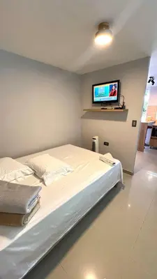 a bedroom with a bed and a flat screen tv at Ideal apartment, view, park and key location in Medellín