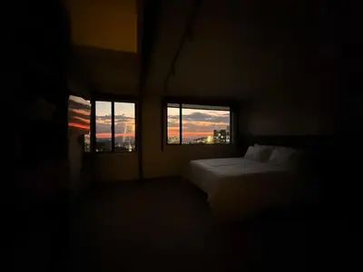 a dark room with a bed and two windows at Estrena Apartamento, Avenida Santander, BREAK SUITES in Manizales
