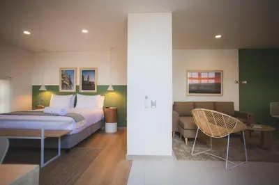 a bedroom with a bed and a couch and a chair at NOK Splendid studio in Laureles Medellin in Medellín