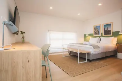 a bedroom with a bed with a desk and a window at NOK Splendid studio in Laureles Medellin in Medellín