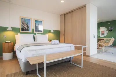 a bedroom with a large bed and a table at NOK Splendid studio in Laureles Medellin in Medellín