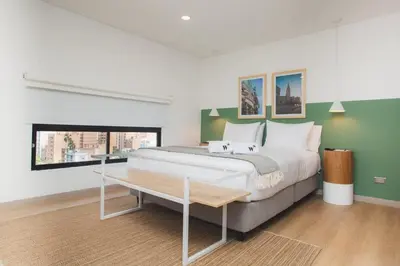 a bedroom with a large bed and a table at NOK Splendid studio in Laureles Medellin in Medellín