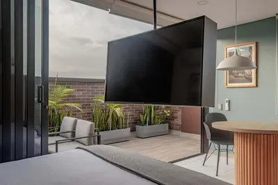 a bedroom with a large flat screen tv on the wall at NOK Perfect 1BR in Laureles Medellin in Medellín