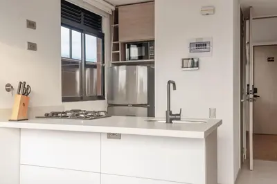 a kitchen with white cabinets and a sink at NOK Perfect 1BR in Laureles Medellin in Medellín