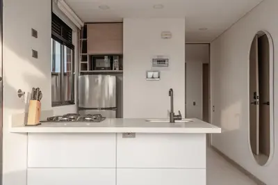 a white kitchen with a sink and a refrigerator at NOK Perfect 1BR in Laureles Medellin in Medellín