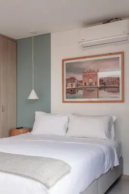 a bedroom with a white bed with a picture on the wall at NOK Perfect 1BR in Laureles Medellin in Medellín