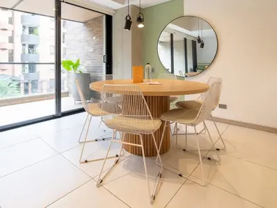 a dining room table with chairs and a mirror at NOK Panoramic 3 BR in Laureles Medellin in Medellín