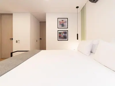 a white bedroom with a large white bed at NOK Panoramic 3 BR in Laureles Medellin in Medellín