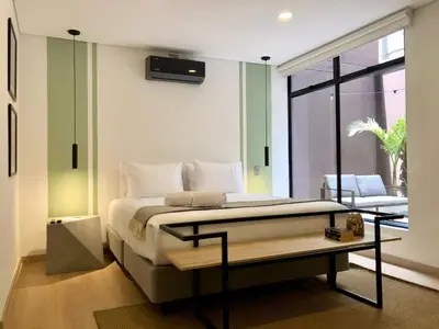 a bedroom with a bed with a television on the wall at NOK Panoramic 3 BR in Laureles Medellin in Medellín