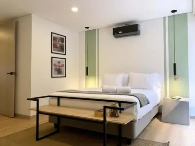 a bedroom with a bed with a tv on the wall at NOK Panoramic 3 BR in Laureles Medellin in Medellín