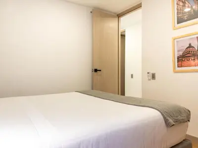 a bedroom with a white bed and a door at NOK Panoramic 3 BR with terrace in Laureles Medellin in Medellín