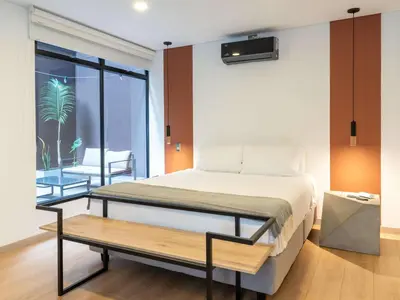 a bedroom with a large bed and a table at NOK Panoramic 3 BR with terrace in Laureles Medellin in Medellín