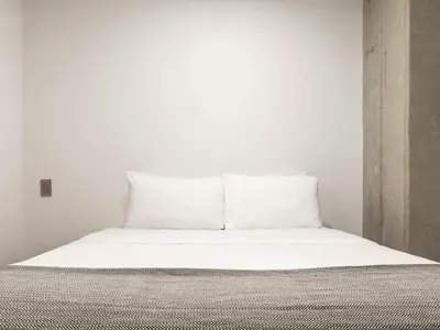 a bed with white sheets and pillows in a room at NOK Panoramic 3 BR with terrace in Laureles Medellin in Medellín