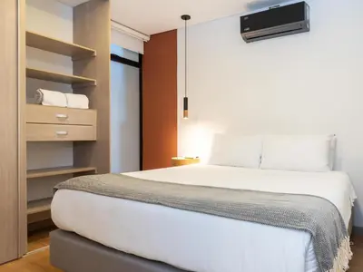 a bedroom with a white bed and a closet at NOK Panoramic 3 BR with terrace in Laureles Medellin in Medellín