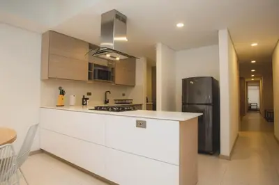 a kitchen with a white counter and a black refrigerator at NOK Cozy 3 BR in Laureles in Medellin in Medellín