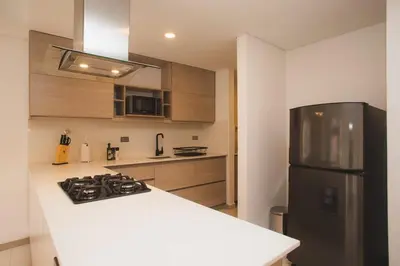 a kitchen with a stove and a refrigerator at NOK Cozy 3 BR in Laureles in Medellin in Medellín