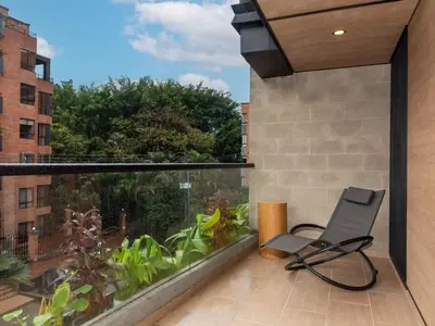 a balcony with a chair and a large aquarium at NOK Cozy 3 BR with Balcony in Laureles Medellin in Medellín