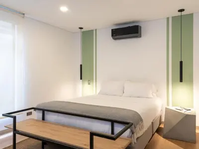 a bedroom with a bed and a table in it at NOK Cozy 3 BR with Balcony in Laureles Medellin in Medellín