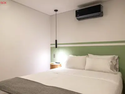 a bedroom with a bed with a tv on the wall at NOK Cozy 3 BR with Balcony in Laureles Medellin in Medellín