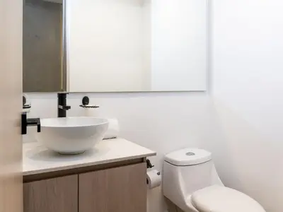 a bathroom with a white sink and a toilet at NOK Cozy 3 BR with Balcony in Laureles Medellin in Medellín