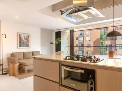 a kitchen and living room with a stove top oven at NOK Perfect 3 BR with Balcony in Laureles Medellin in Medellín