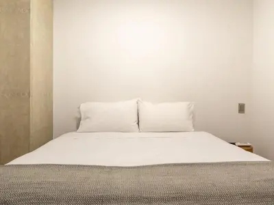 a white bed with two pillows on top of it at NOK Perfect 3 BR with Balcony in Laureles Medellin in Medellín