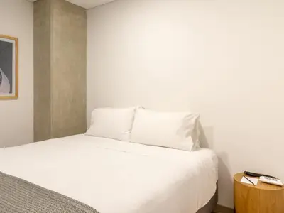 a bed with white sheets and pillows in a room at NOK Perfect 3 BR with Balcony in Laureles Medellin in Medellín