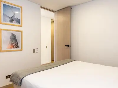 a bedroom with a white bed and a mirror at NOK Perfect 3 BR with Balcony in Laureles Medellin in Medellín