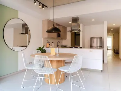 a kitchen with a wooden table and white chairs at NOK Fancy 3BR Balcony in Laureles Medellin in Medellín