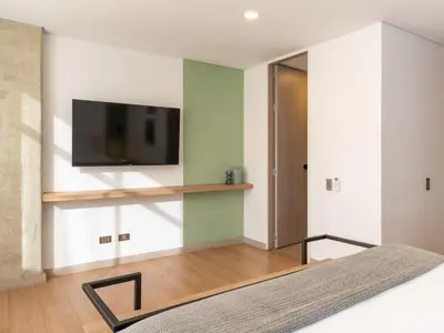 a bedroom with a flat screen tv on a wall at NOK Fancy 3BR Balcony in Laureles Medellin in Medellín