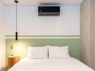 a bedroom with a white bed with a tv above it at NOK Stylish 3BR in Laureles MDE in Medellín