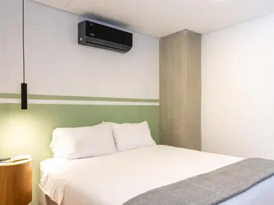 a bedroom with a bed with a tv on the wall at NOK Stylish 3BR in Laureles MDE in Medellín