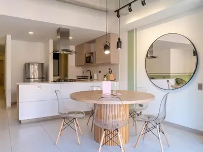 a kitchen with a table and chairs and a mirror at NOK Stylish 3BR in Laureles MDE in Medellín