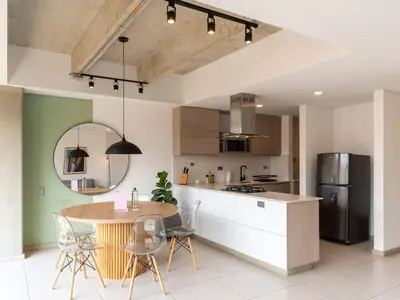a kitchen with a table and chairs and a refrigerator at NOK Charming 3BR in Laureles Medellin in Medellín