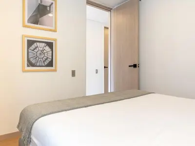 a bedroom with a white bed and a window at NOK Charming 3BR in Laureles Medellin in Medellín