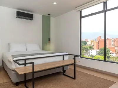 a bedroom with a bed and a large window at NOK Charming 3BR in Laureles Medellin in Medellín