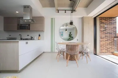 a kitchen and dining room with a table and chairs at NOK Amazing with Balcony 3 BR in Laureles Medellin in Medellín