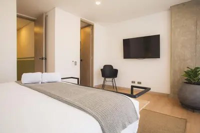 a bedroom with a bed with a tv on the wall at NOK Amazing with Balcony 3 BR in Laureles Medellin in Medellín