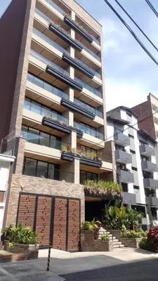 a large apartment building with a garage in front of it at NOK Amazing with Balcony 3 BR in Laureles Medellin in Medellín