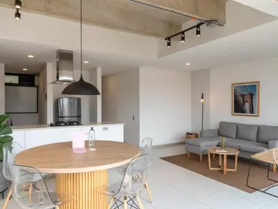 a kitchen and living room with a table and a couch at NOK Lovely 3 BR with Balcony in Laureles Medellin in Medellín