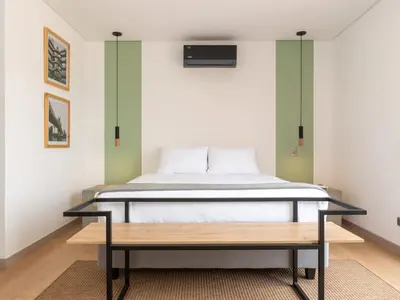 a bedroom with a bed and a bench in it at NOK Lovely 3 BR with Balcony in Laureles Medellin in Medellín