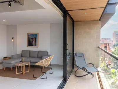 a living room with a couch and chairs on a balcony at NOK Lovely 3 BR with Balcony in Laureles Medellin in Medellín