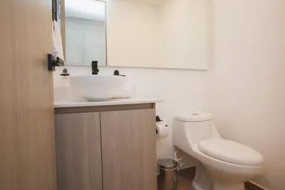 a bathroom with a sink and a toilet and a mirror at NOK Perfect 3 BR in Laureles in Medellin in Medellín
