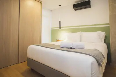 a bedroom with a large bed with white sheets at NOK Perfect 3 BR in Laureles in Medellin in Medellín