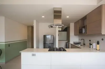 a kitchen with a white counter top and wooden cabinets at NOK Perfect 3 BR in Laureles in Medellin in Medellín