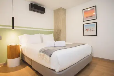 a bedroom with a large white bed in a room at NOK Cool 3 BR With Balcony in Laureles Medellin in Medellín